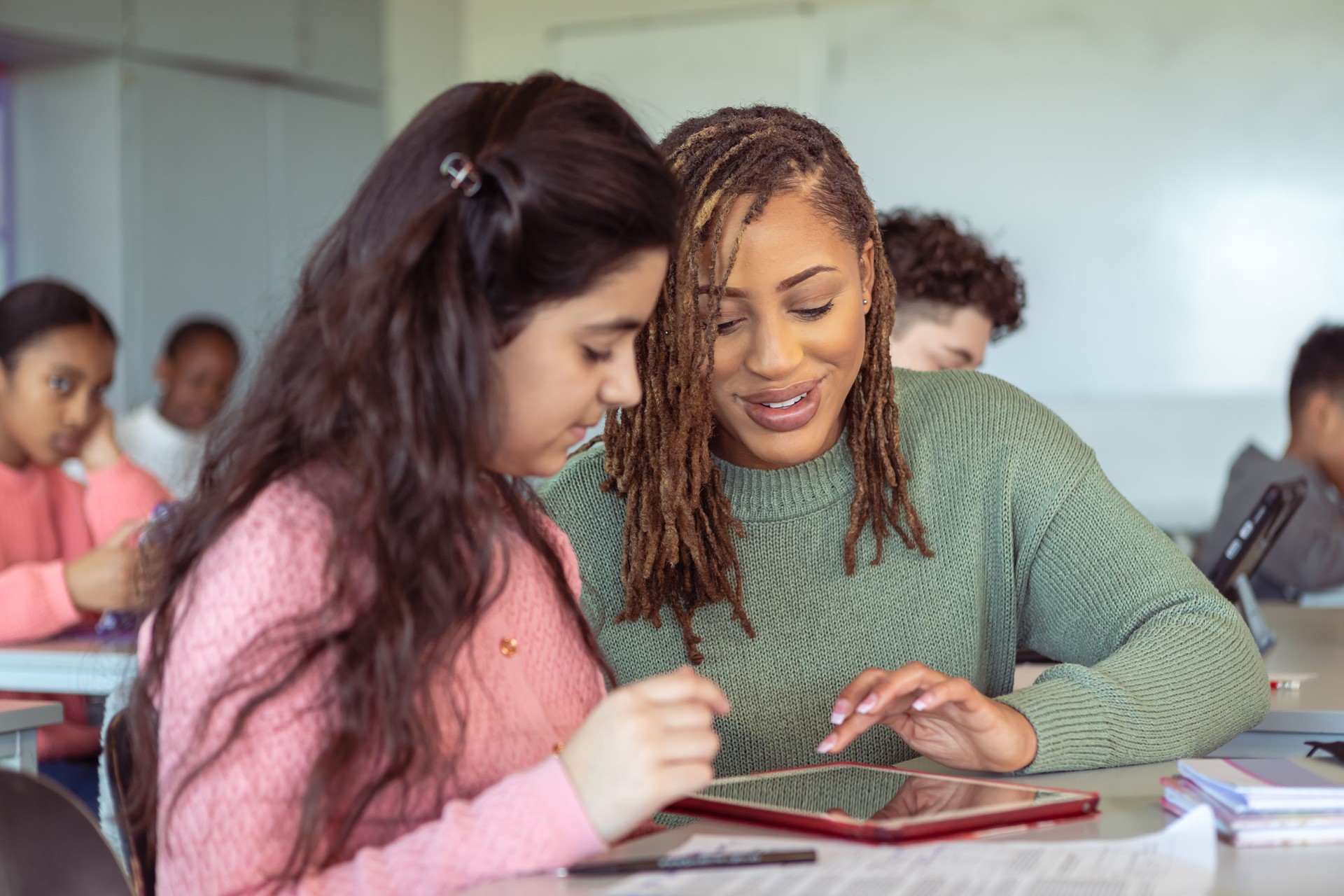 Teacher helping student with assignment on tablet computer